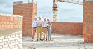 profissionais da construcao civil observando planta com automatizacao de processos